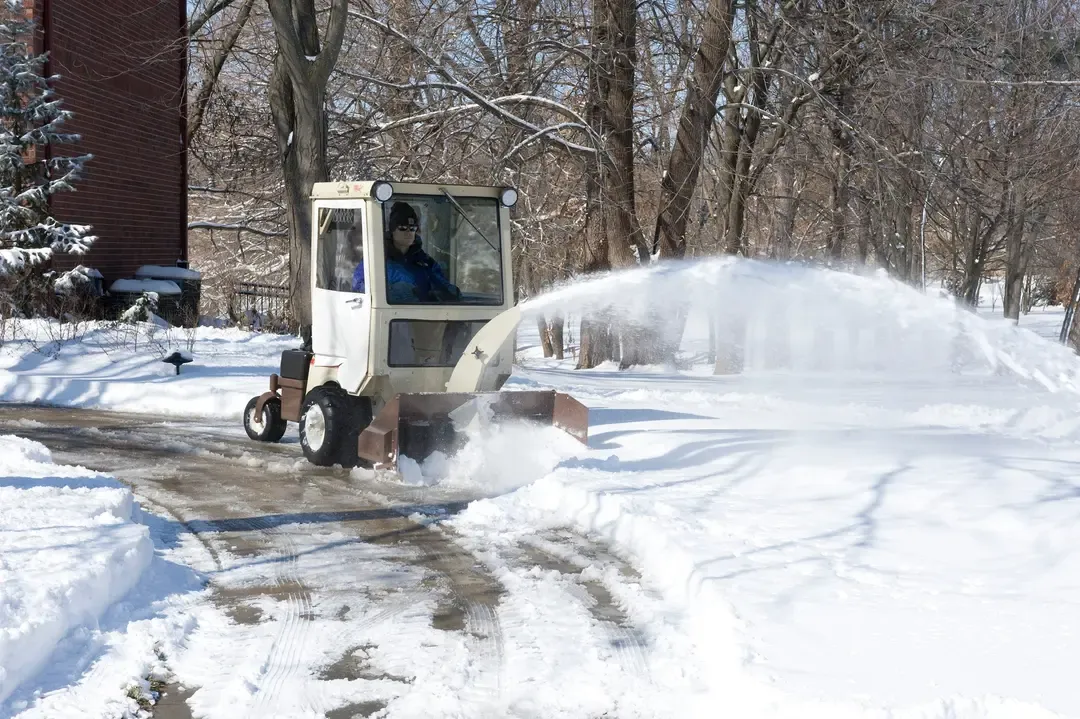 Grasshopper tractor running a snowthrower attachment in winter